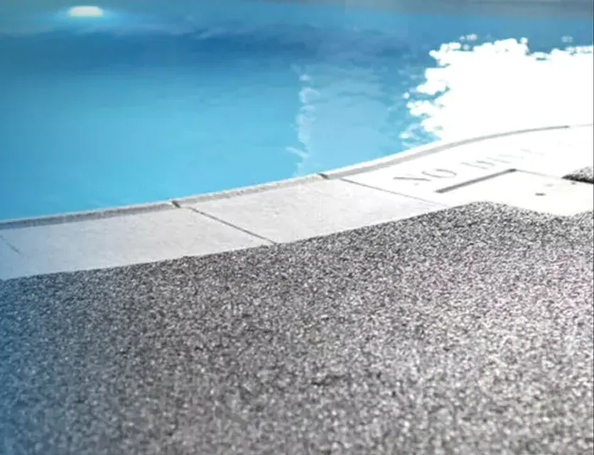 Textured, slip-resistant coated pool and roof deck