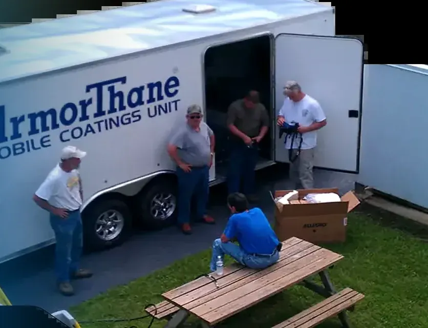 An ArmorThane mobile coatings unit trailer with its doors open at a training event